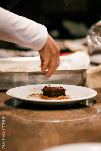 Garnishing a brownie with almond slivers, perfect for image stock and recipe sites.
