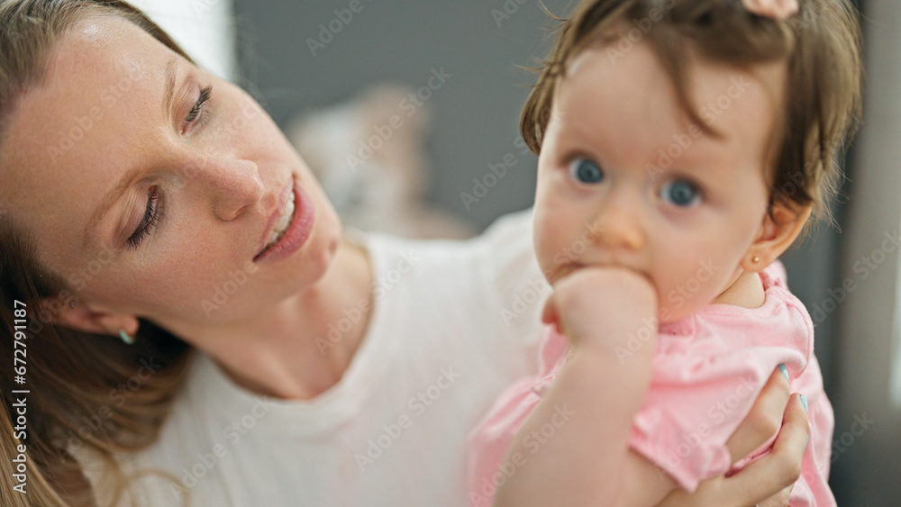Mother and daughter hugging each other sitting on sofa at home Mother and daughter hugging each other sitting on sofa at home