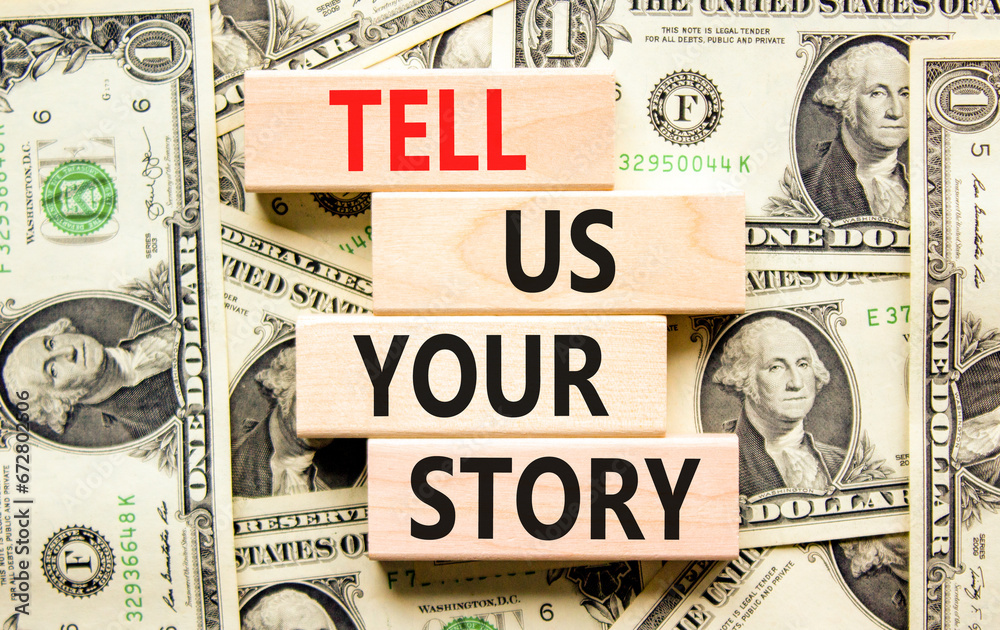 Tell us your story symbol. Concept word Tell us your story on beautiful wooden block. Dollar bills. Beautiful background from dollar bills. Business tell us your story concept. Copy space.