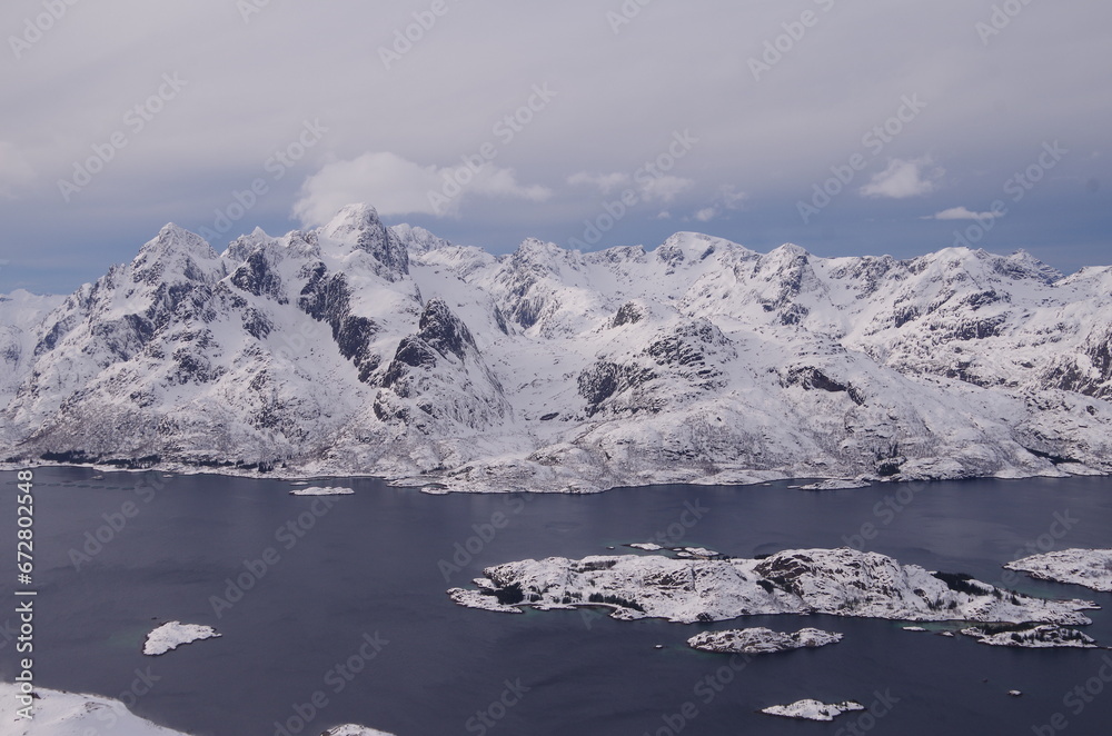 Lofoten Islands in winter time: ski touring, snowy mountains, red houses, fishermen boats and scenic landscapes