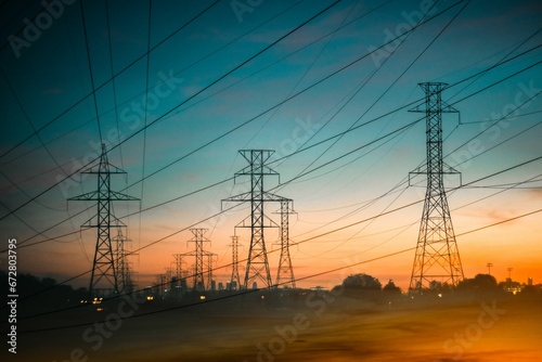 Energy power lines against a backdrop of a beautiful orange and yellow sunset sky