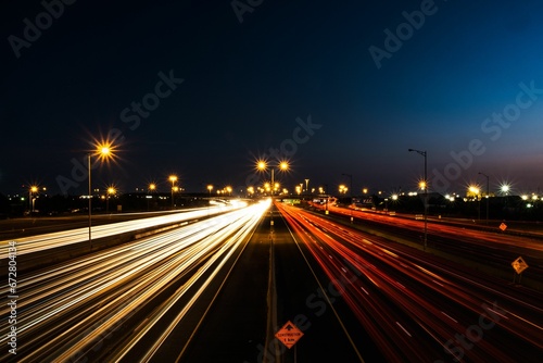 Long exposure shot of night traffic on a freeway near street lights