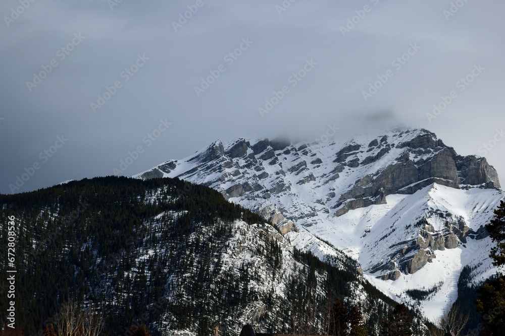 Mesmerizing landscape of the snowy mountain range its peaks covered with clouds