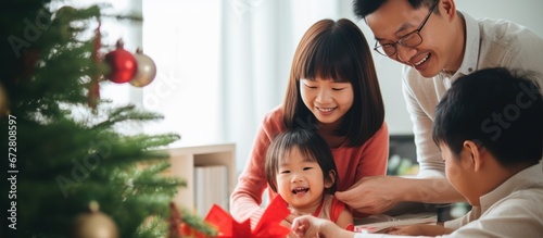 Asian Family celebrating christmas new year and. Home holiday and Christmas tree © ETAJOE