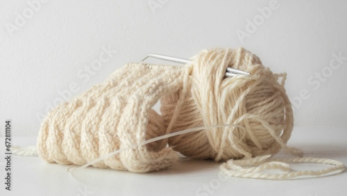 Closeup of a yarn of beige thread on a white background