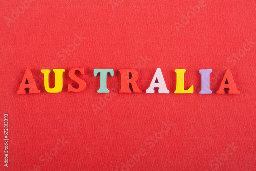 AUSTRALIA word on red background composed from colorful abc alphabet block wooden letters, copy space for ad text. Learning english concept.