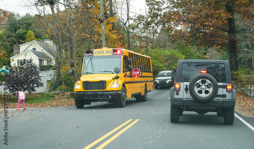 yellow school bus stopping on residential street