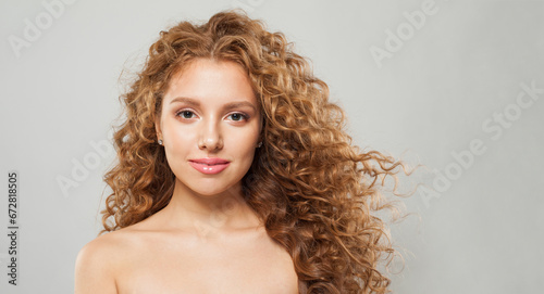 Fashionable stylish young female model with curly long brown hairstyle on white background. Woman with wavy hair