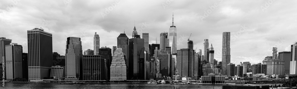 A black and white scene of the cityscape of New York City, with skyscrapers piercing the skyline