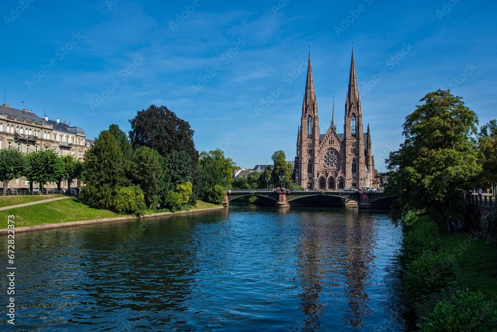 Landscape view of the Cathedral of Strasbourg with a picturesque river under it