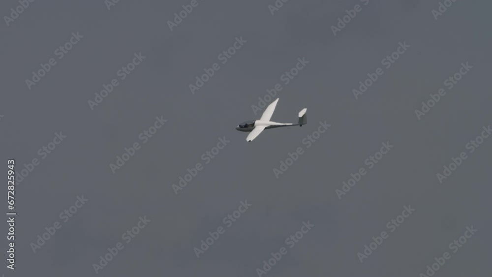 Glider is landing on a small airfield. Non-motorized aircraft. Glider against blue sky Glider is landing on a small airfield. Non-motorized aircraft. Glider against blue sky