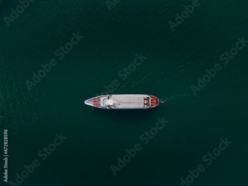 Aerial view of a white boat floating through the sea