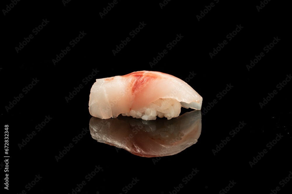 Close-up shot of nigirizushi on a black reflective surface. Close-up shot of nigirizushi on a black reflective surface.