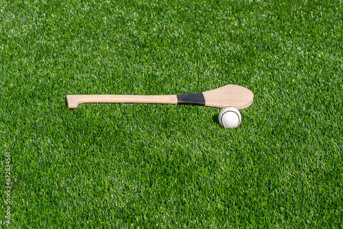 Hurling bat and sloitar on green grass. Horizontal sport theme poster, greeting cards, headers, website and app photo
