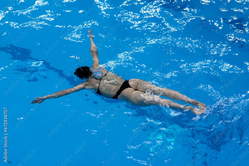 a female sport swimming athlete swimming underwater in the pool