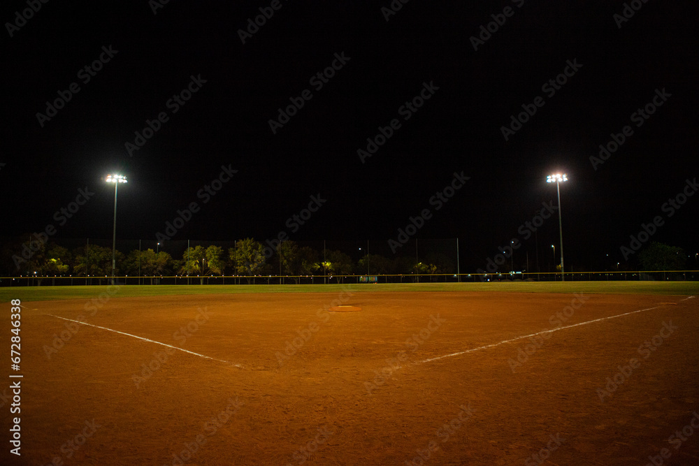 Empty baseball field at night, view from home plate