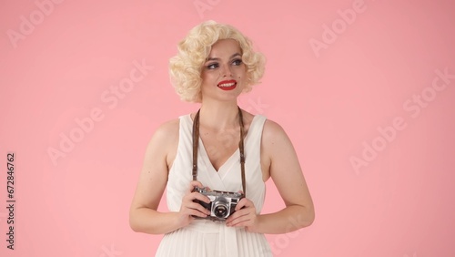 Фотография A woman holds up an old vintage camera