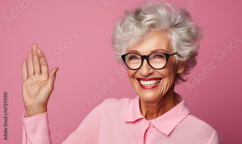 Cheerful senior woman waving with a smile.