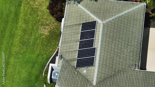 Aerial view of regular American home roof with blue solar photovoltaic panels for producing clean ecological electric energy. Renewable electricity with zero emission concept photo