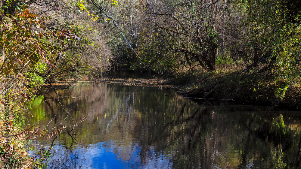 Scenic view of Calumet Creek near Clarksville, Missouri with surrounding landscape reflected in its waters Scenic view of Calumet Creek near Clarksville, Missouri with surrounding landscape reflected in its waters