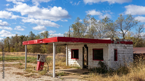 An abandoned derelict gas station with one broken pump