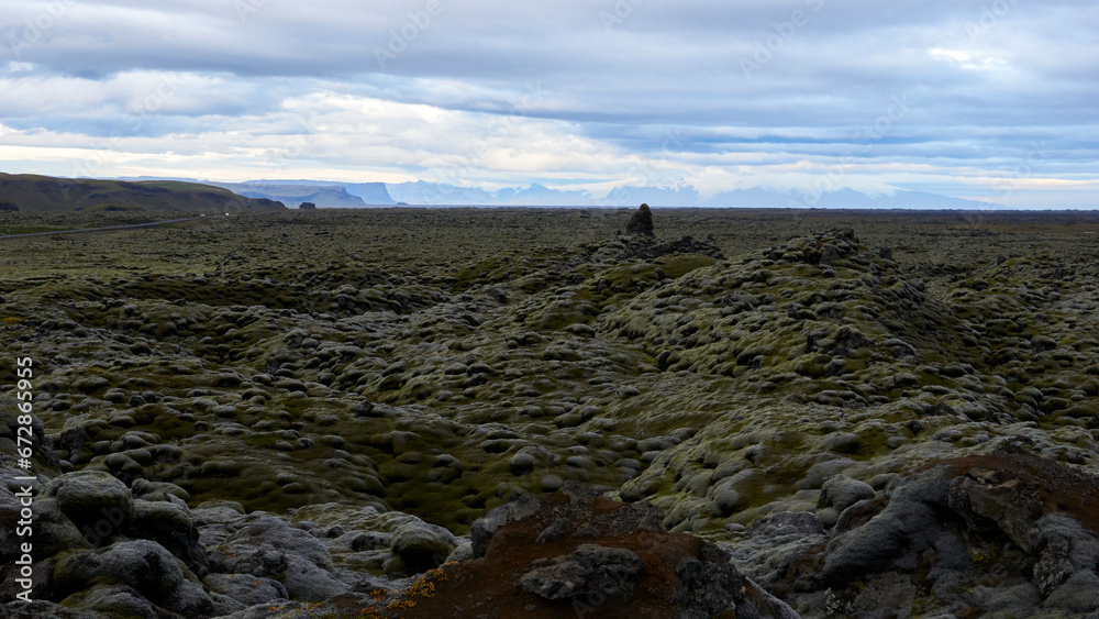 mountains and vatnajökull glacier in the background of mossy lava field in iceland