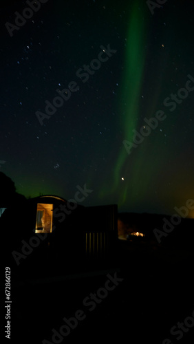 aurora borealis behind sauna in iceland