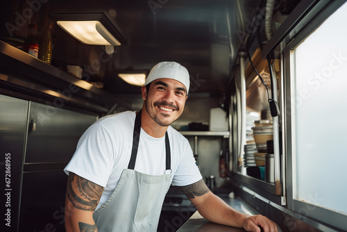 Latin American male chef preparing takeaway food in food truck kitchen photo