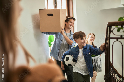 Family carrying boxes into a new apartment