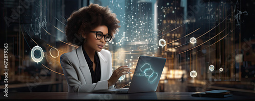 Woman with afro hair sltyle sitting and working with laptop in her office.