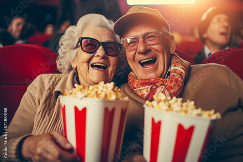 Happy senior couple with popcorn at cinema photo