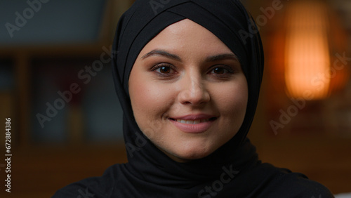 Photography Portrait of Arabian muslim woman in black traditional hijab looking at camera and smiling toothy dental smile
