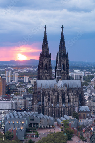 Dramatic storm clouds over Cologne Cathedral and Hohenzollern Bridge in the sunset photo