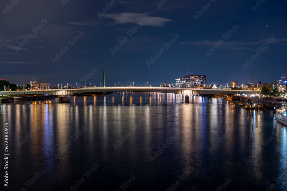 Evening view of the Deutz Bridge in Cologne, lights reflected in the Rhine