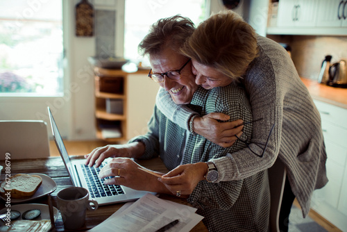 Mature couple online shopping with laptop at home photo