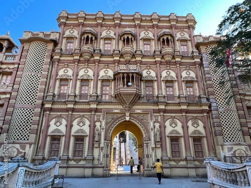 Grand and majestic palace building with a few people walking down the front of the structure photo