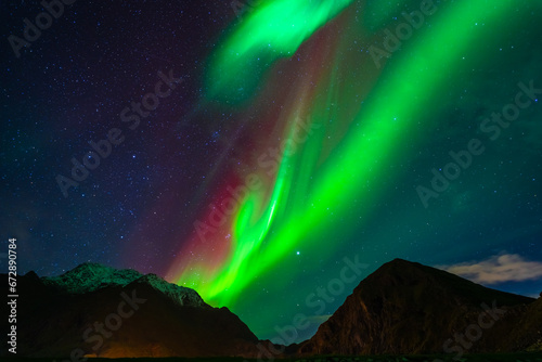 Awesome Northern lights over the snowy mountains. Lofoten islands, Norway. © mario