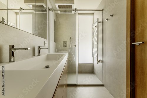 Wallpaper Mural Beautiful modern bathroom with gray stone-like tiles, large mirror integrated into the wall, heated towel rail and chrome in the shower, skylight in the shower cabin and long double sink Torontodigital.ca
