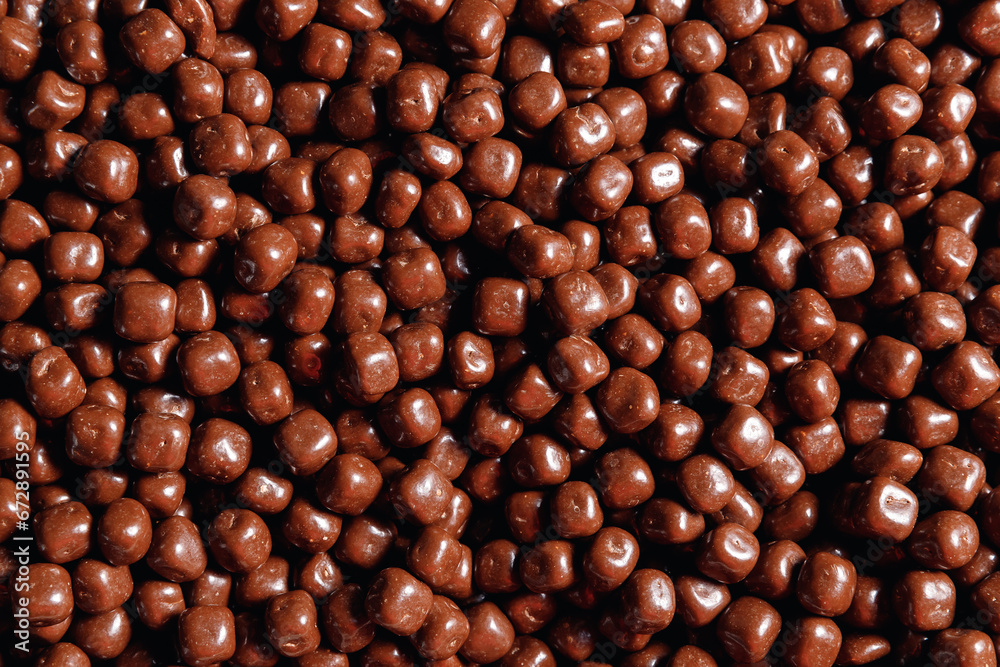 Closeup brown dragee, chocolate covered nuts, sweet candy background