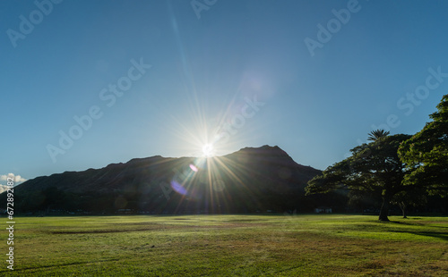 Scenic Kapiolani Regional Park vista in Honolulu, Hawaii, with sun rising over the Diamond Head mountain photo