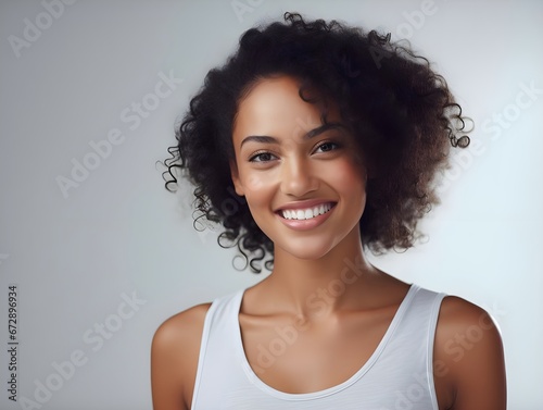 Pretty woman with curly hair on gray background, copy space.