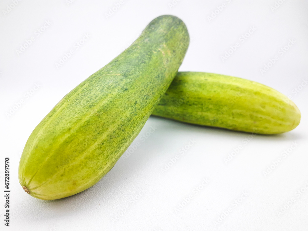 2 cucumbers isolated on a white background, this fruit contains a lot of water so it is very refreshing but tastes bland, can be eaten directly or cooked, often also used as a garnish or facial mask