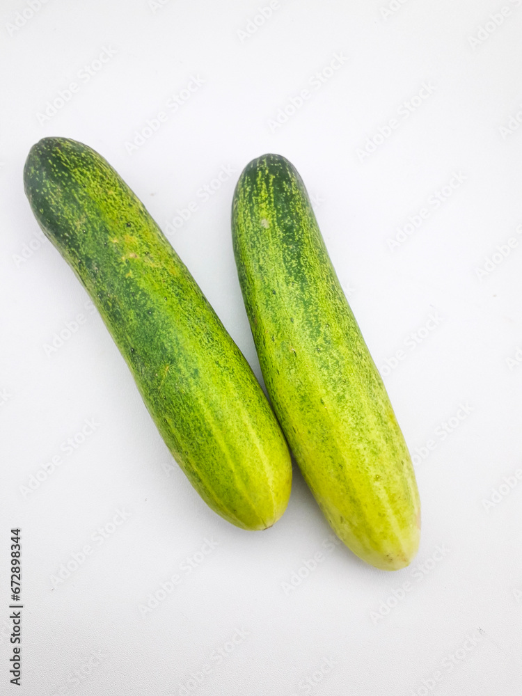 2 cucumbers isolated on a white background, this fruit contains a lot of water so it is very refreshing but tastes bland, can be eaten directly or cooked, often also used as a garnish or facial mask 2 cucumbers isolated on a white background, this fruit contains a lot of water so it is very refreshing but tastes bland, can be eaten directly or cooked, often also used as a garnish or facial mask