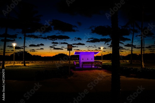 Small booth with a sign: Miami Beach at sunset. Florida, USA.