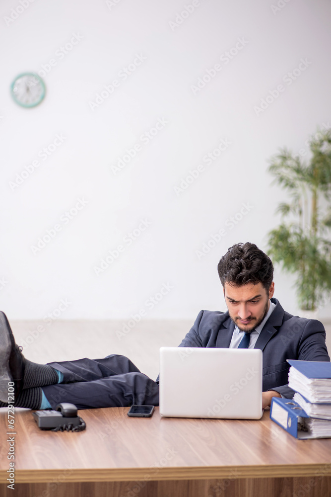 Young male employee working in the office Young male employee working in the office