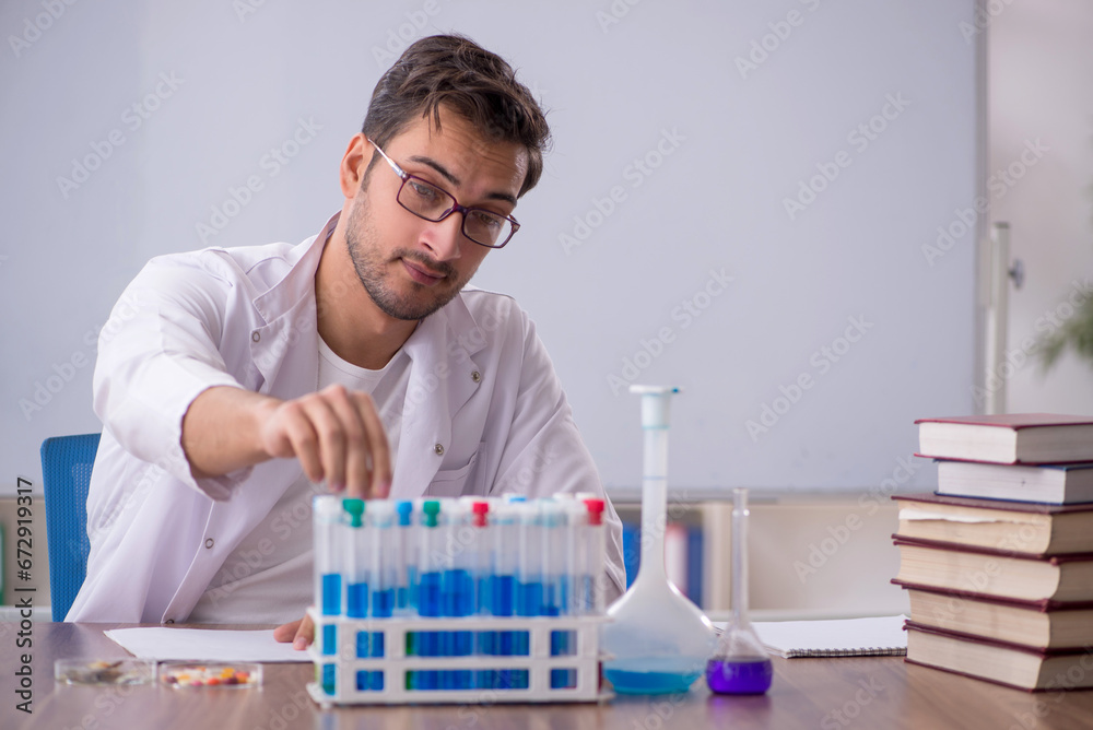 Young male chemist in front of white board Young male chemist in front of white board