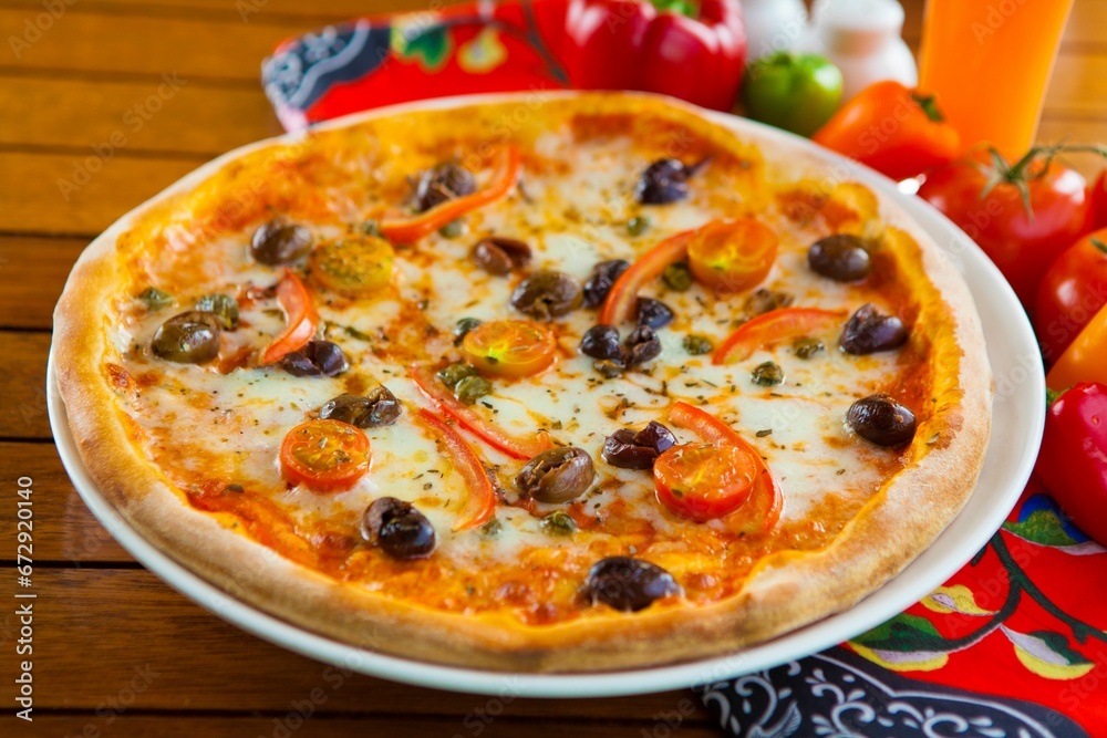Closeup of a delicious pizza with olives and melted cheese on the table