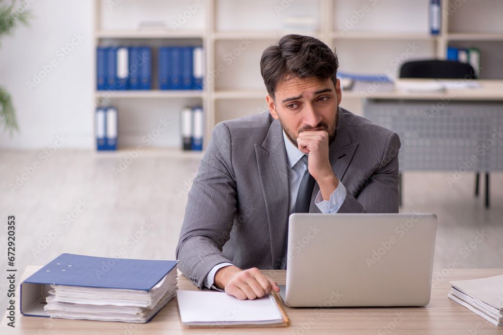 Young male employee working in the office Young male employee working in the office