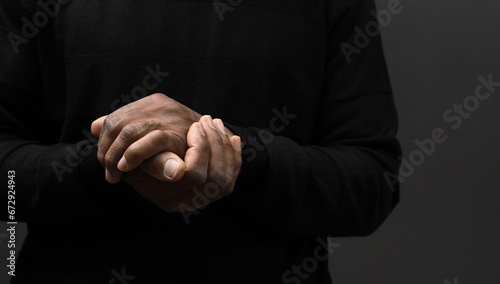 praying to God with hands together on grey black background with people stock image stock photo 