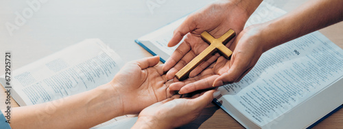 Close-up women prayer deliver holy bible book and holy cross to young believer. Spreading religion symbol. Concept of hope, religion, christianity and god blessing. Warm background. Burgeoning.